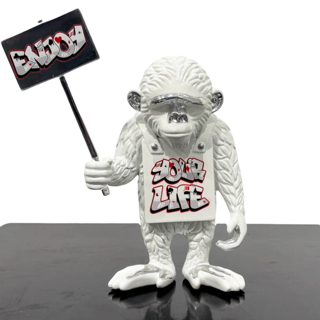 Sculpture of an white monkey with white Enjoy Your Life sign and crown